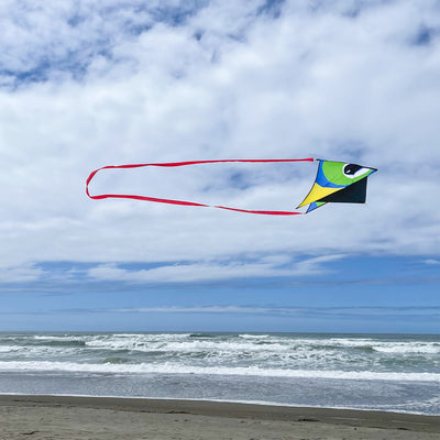 20-foot Continuous Kite Tail in vibrant red attached to a kite, flowing elegantly in the wind against a clear blue sky.