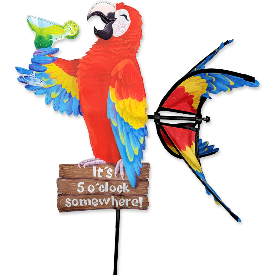Colorful 20 in. Island Parrot Spinner featuring a playful parrot design displaying 'It's 5 o'clock somewhere!' in a garden setting.