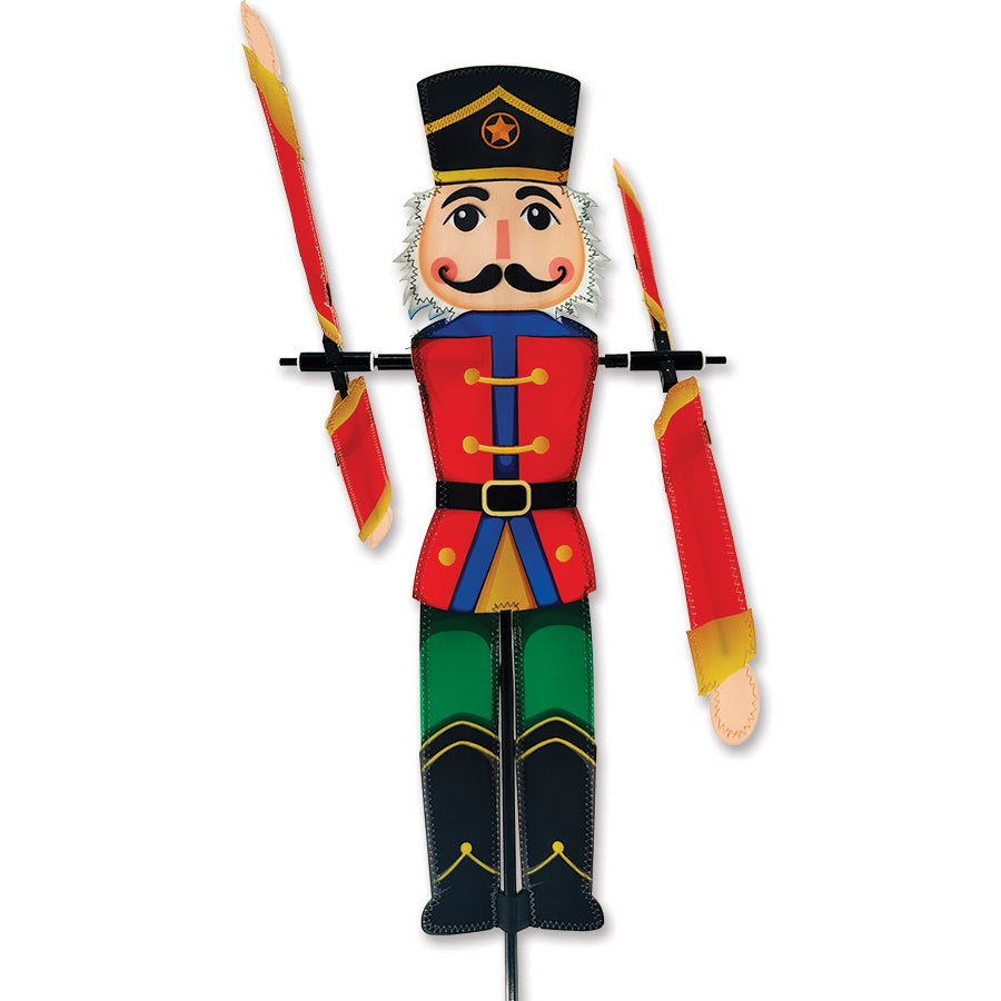 20 in. Nutcracker WhirliGig Spinner made of SunTex fabric, spinning in a gentle breeze in a colorful garden setting.