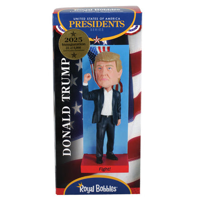 2025 Inauguration Limited Edition Donald Trump Bobblehead featuring a raised fist and American flag backdrop displayed on a shelf.