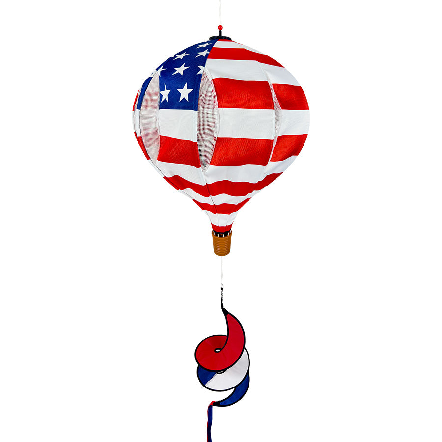 22 in. Pop-Open Hot Air Balloon in vibrant patriotic colors spinning in the wind, displayed on a deck as an outdoor decoration.