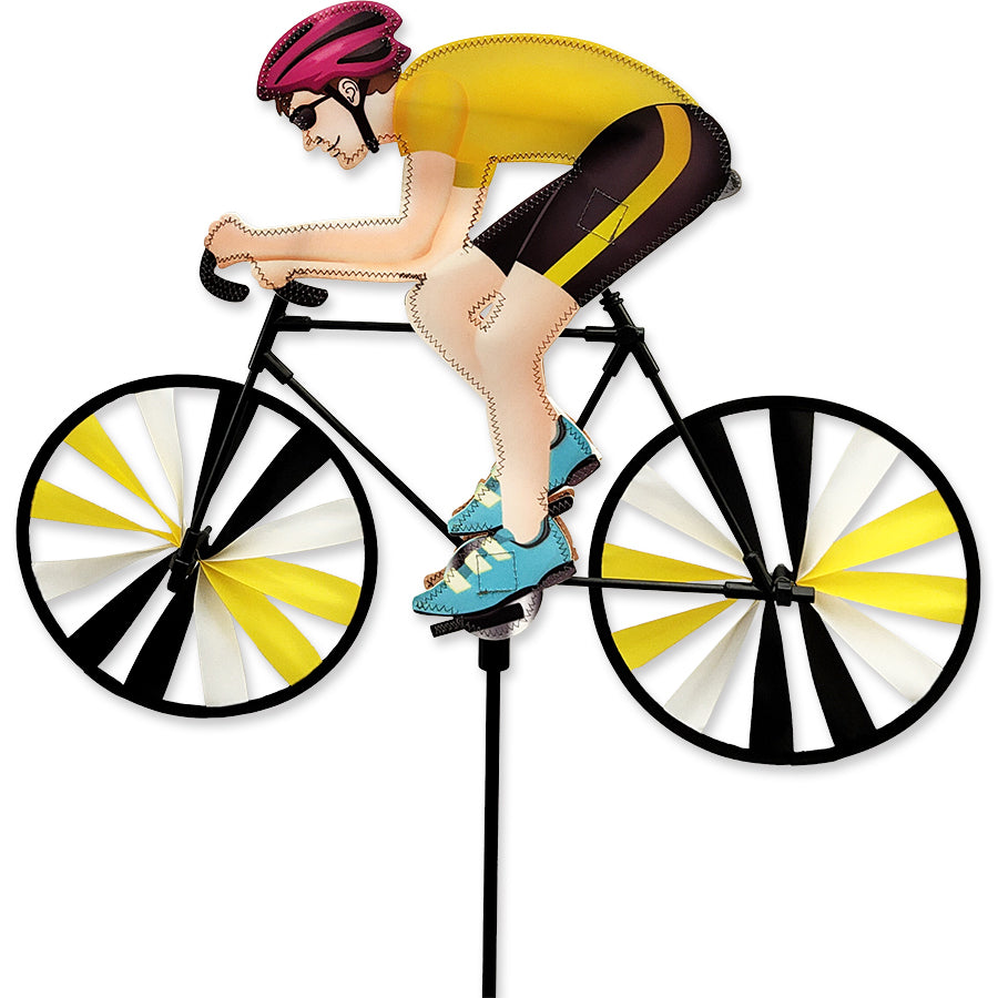 22 in. Road Bike Spinner featuring a colorful design, spinning in the wind, enhancing an outdoor garden with vibrant bike-themed decor.