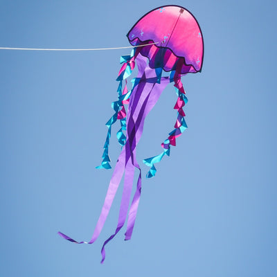 22-inch Jellyfish Dancing Dragon Kite with colorful tails flying in the sky, showcasing its vibrant jellyfish design during a sunny outdoor event.