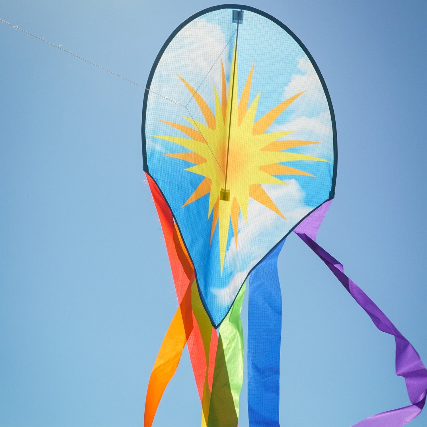 22-inch Sun & Rainbow Dancing Dragon Kite with colorful tails flying against a clear blue sky during a sunny day.
