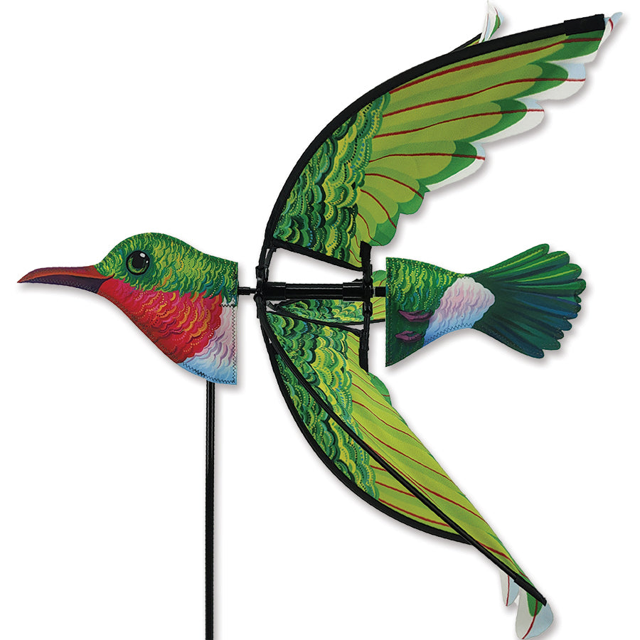 A vibrant 24 in. Ruby Throated Hummingbird decoration displayed in a garden, showcasing detailed features and bright colors against green foliage.