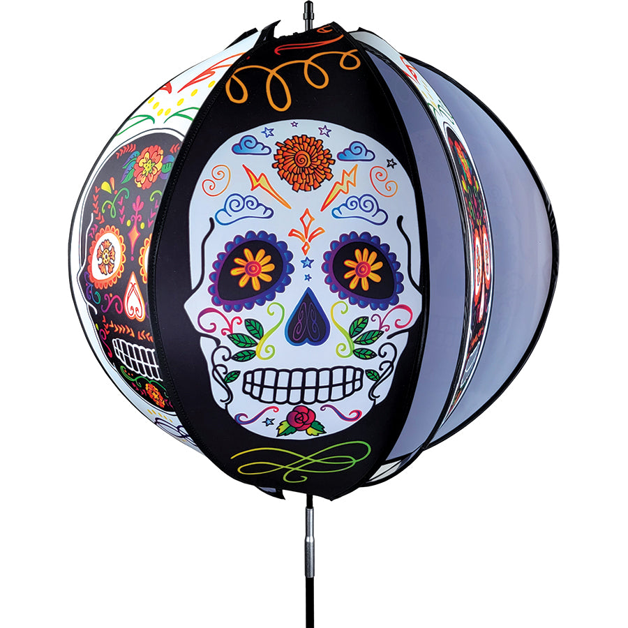 24-inch Day of the Dead ball spinner with six colorful panels rotating in an outdoor garden setting, showcasing intricate designs.