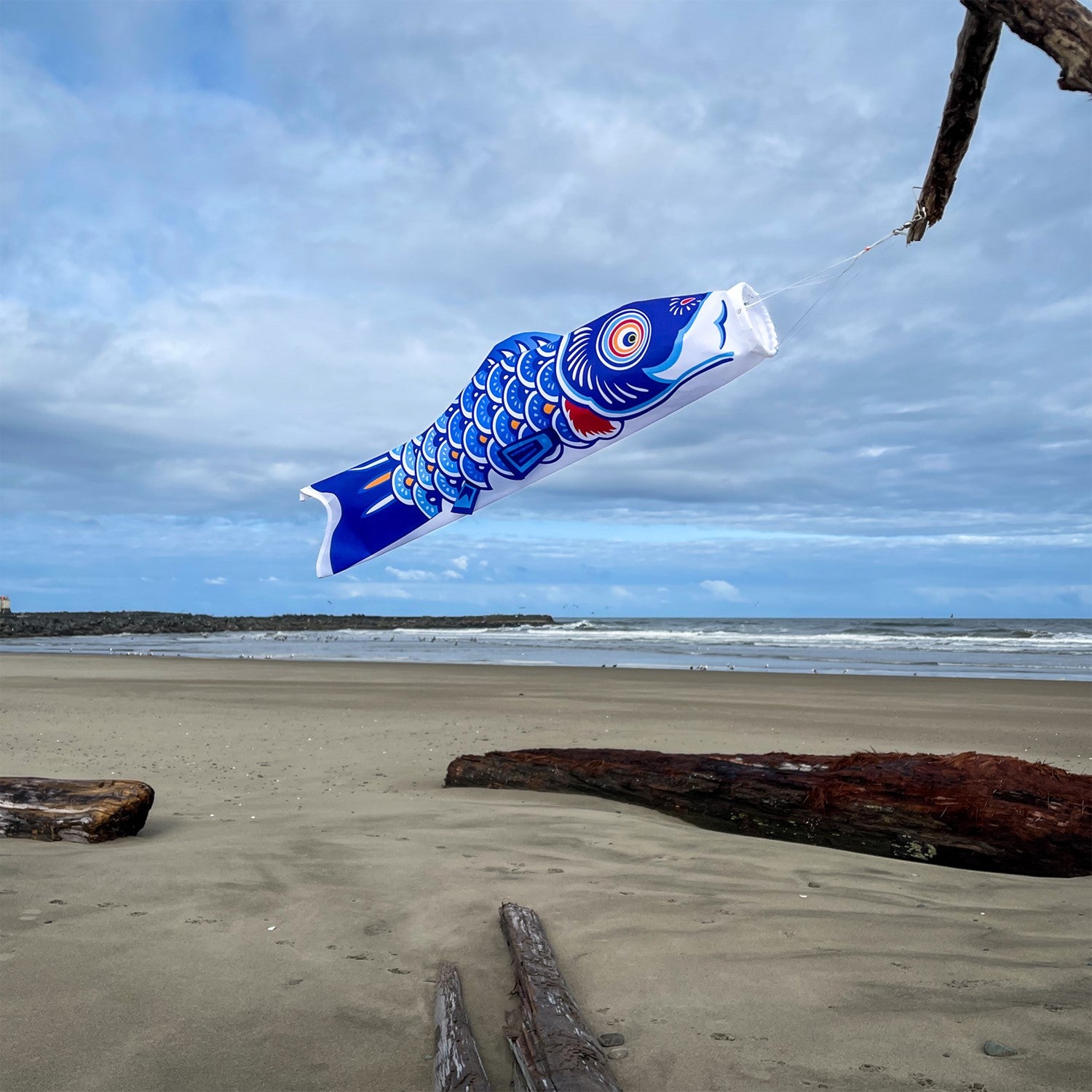 24-inch Blue Koi windsock displayed in a garden setting, showcasing vivid colors and intricate designs that flutter in the wind.