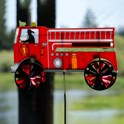 Vibrant 24'' Fire Truck Spinner in a garden setting with spinning wheels, showcasing a charming red fire truck design in motion.