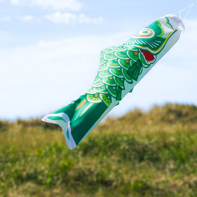 24\" Green Koi windsock featuring intricate fish design, fluttering in the breeze, showcasing vibrant colors against a clear sky backdrop.