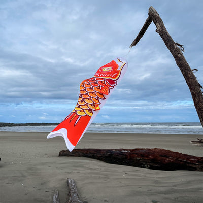 24-inch Orange Koi fish windsock displayed outdoors, featuring a vibrant design that flutters in the wind, perfect for garden decoration.