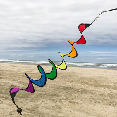 24-inch Rainbow Curlie hanging outdoors, showcasing vibrant colors in swirling patterns, dancing in the breeze with sunny background.