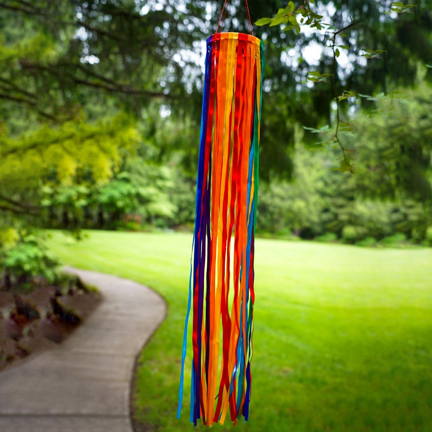 24-inch Rainbow Ribbon Windsock featuring shiny satin ribbons in a spectrum of colors, hanging outdoors, gently swaying in the breeze.
