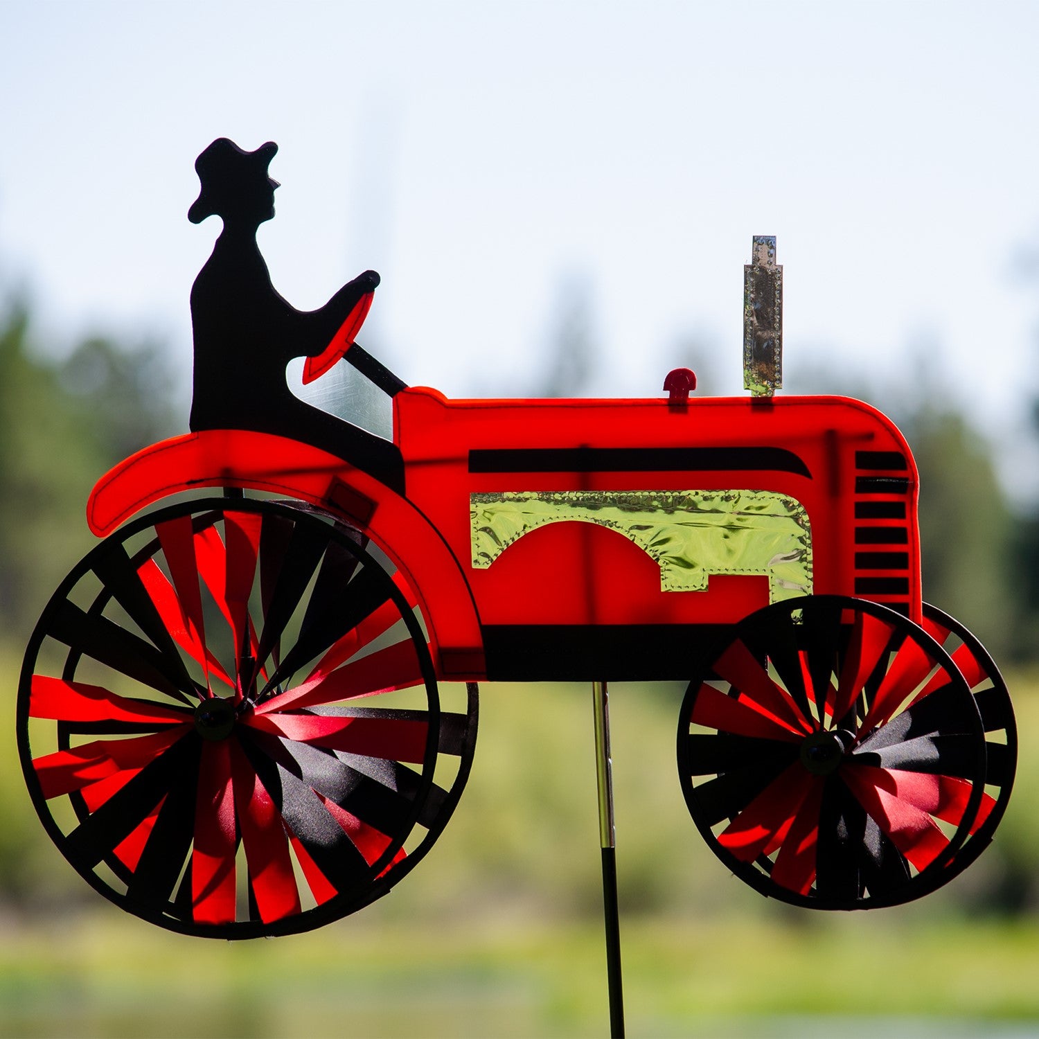 24-inch Red Tractor Spinner with four vibrant spinning wheels and applique details, delightfully showcased in an outdoor garden setting.