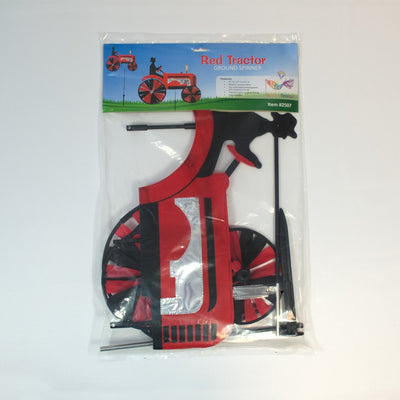 24-inch Red Tractor Spinner with four vibrant spinning wheels and applique details, delightfully showcased in an outdoor garden setting.