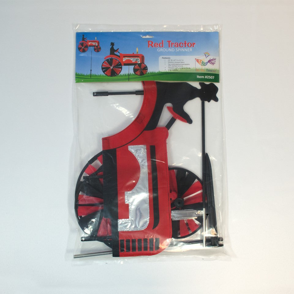 24-inch Red Tractor Spinner with four vibrant spinning wheels and applique details, delightfully showcased in an outdoor garden setting.