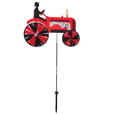 24-inch Red Tractor Spinner with four vibrant spinning wheels and applique details, delightfully showcased in an outdoor garden setting.