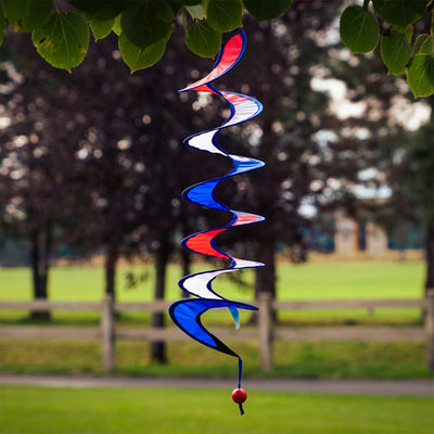 24-inch Red, White and Blue Curlie spinner hanging outdoors, displaying a vibrant spiral design in patriotic colors, gently swirling in the breeze.