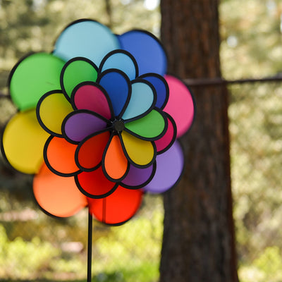 24-Petal Flower Triple Wheel Spinner featuring vibrant rainbow-colored petals spinning in a garden setting, creating a playful decoration.