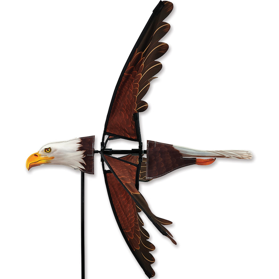 25 in. Flying Eagle Spinner, a colorful garden decoration rotating in the breeze against a backdrop of greenery.