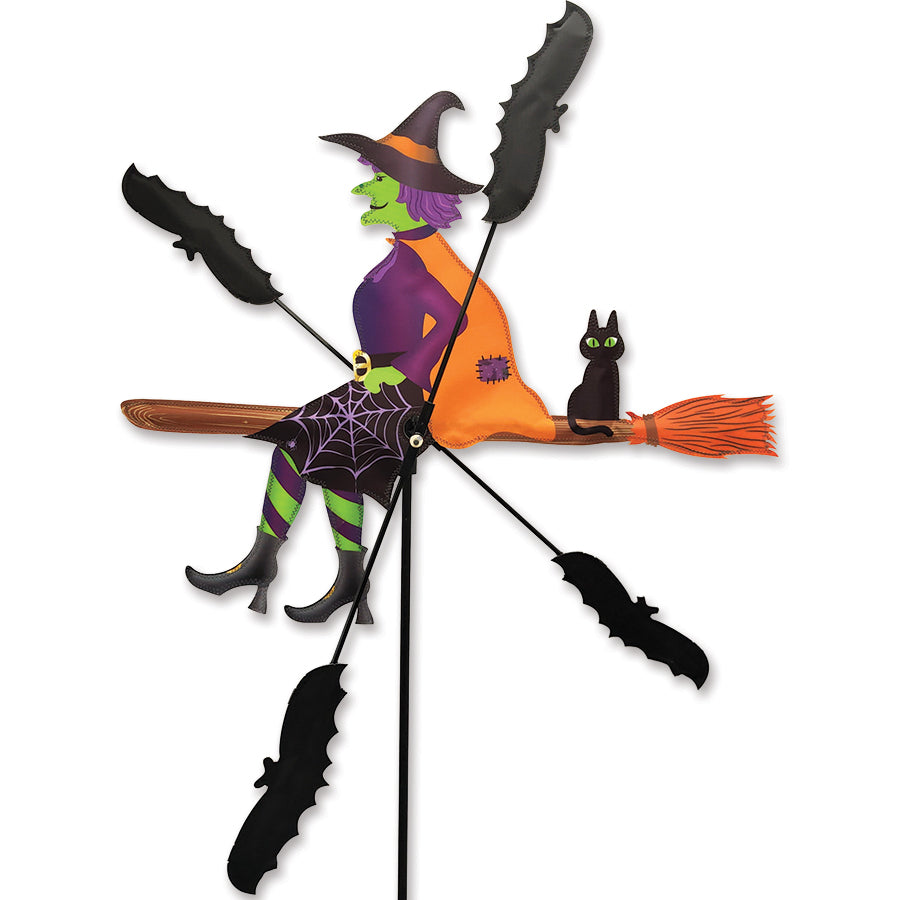 26-inch WhirliGig Spinner featuring a whimsical witch design, spinning playfully in a garden setting, enhancing outdoor decor.