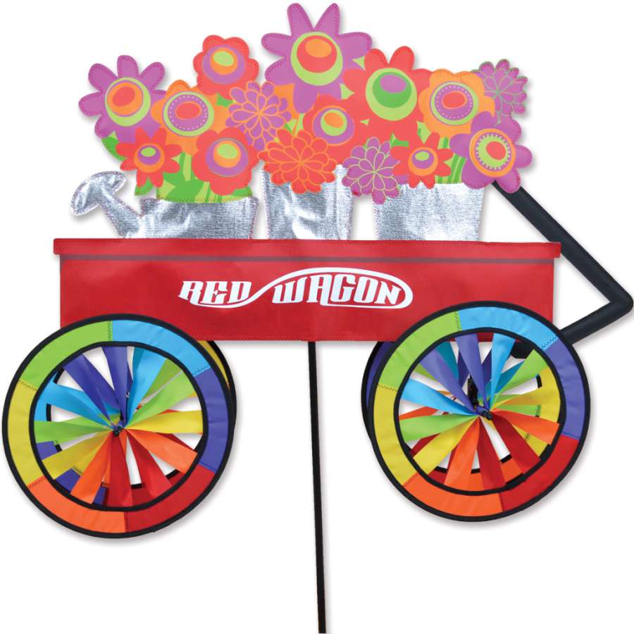 27 in. Red Wagon Spinner in bright red, spinning gracefully in a garden surrounded by green plants, adding a playful touch to the outdoor decor.