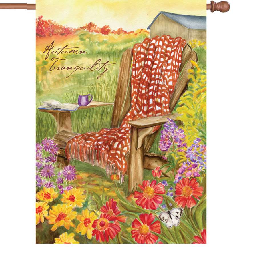 Illuminated 28 in. Autumn Tranquility flag showcasing vibrant fall colors and tranquil imagery displayed in a garden setting.