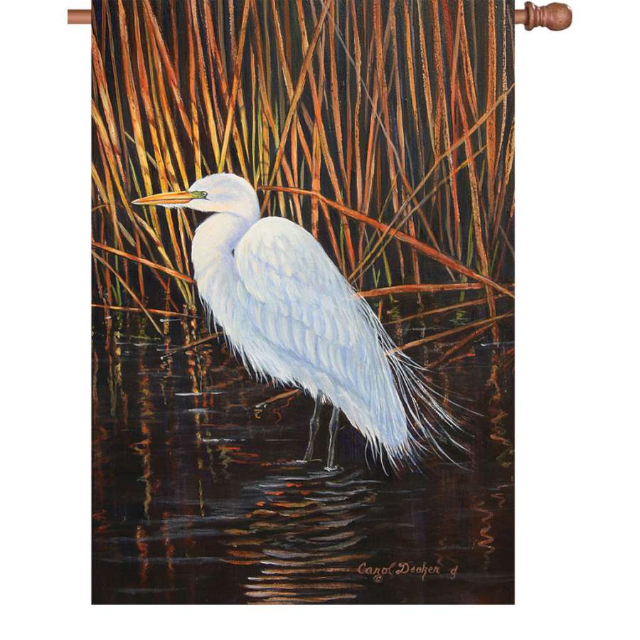 28 in. Egret Flag showcasing vibrant colors and an elegant egret design, illuminated for nighttime display in a garden setting.