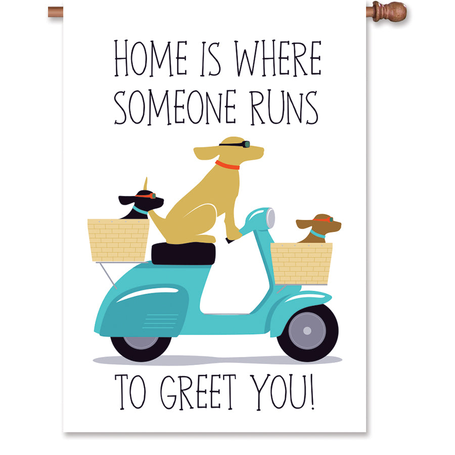 28 in. house flag featuring three dogs on a scooter with the text 'Home Is Where Someone Runs to Greet You!' in vibrant colors.