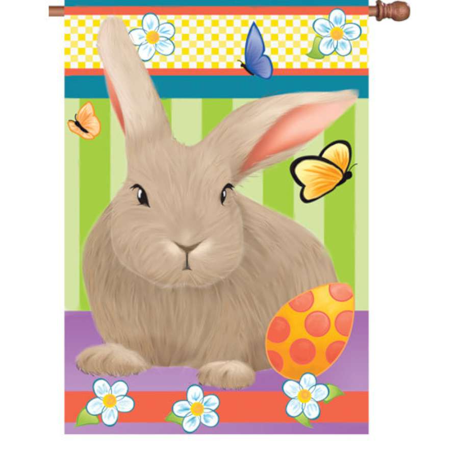 28 in. Hip Hop Bunny house flag showcasing a colorful bunny in a hip hop pose, displayed outdoors in a vibrant garden setting.
