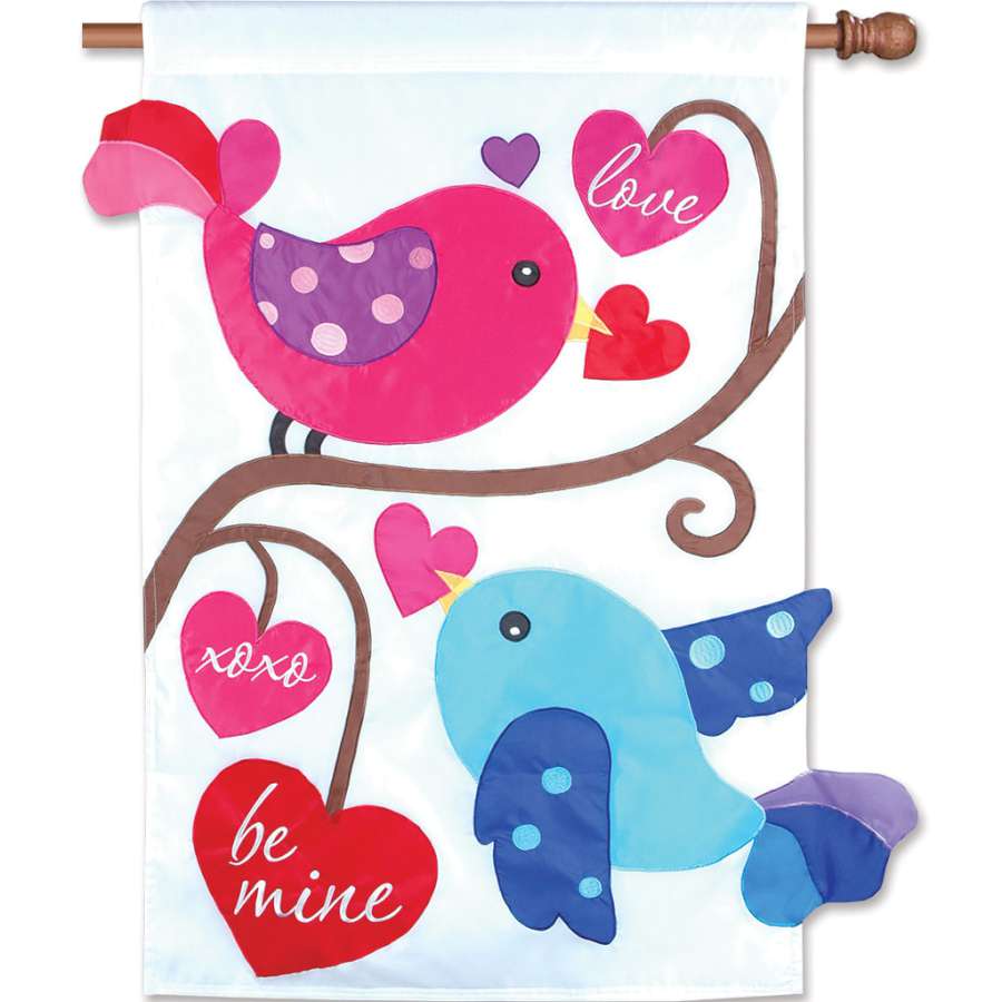 28 inch double-sided Love Birds flag featuring vibrant bird designs and affectionate text, displayed outdoors in a garden setting.