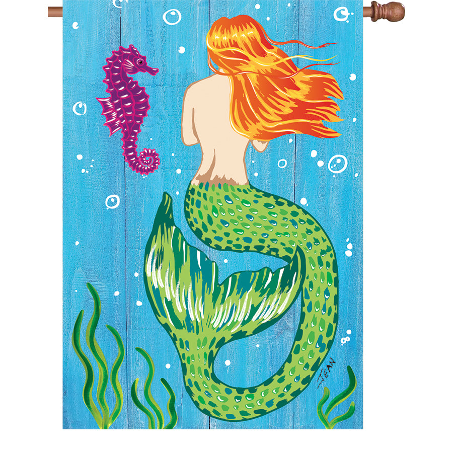28 in. Mermaid & Seahorse Flag crafted from PremierSoft fabric, featuring vibrant ocean graphics, fluttering in the breeze on a house flagpole.