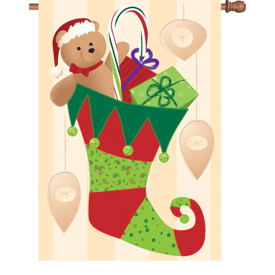 Colorful 28 in. stocking stuffer flag displayed outdoors, enhancing a winter holiday setting with festive charm.