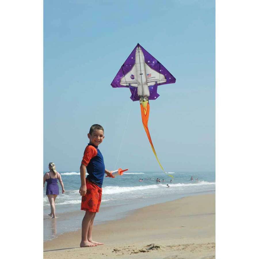 2D Jet Kite - Space Shuttle with realistic design flying in an open blue sky, showcasing its vibrant colors and long streamer tails.