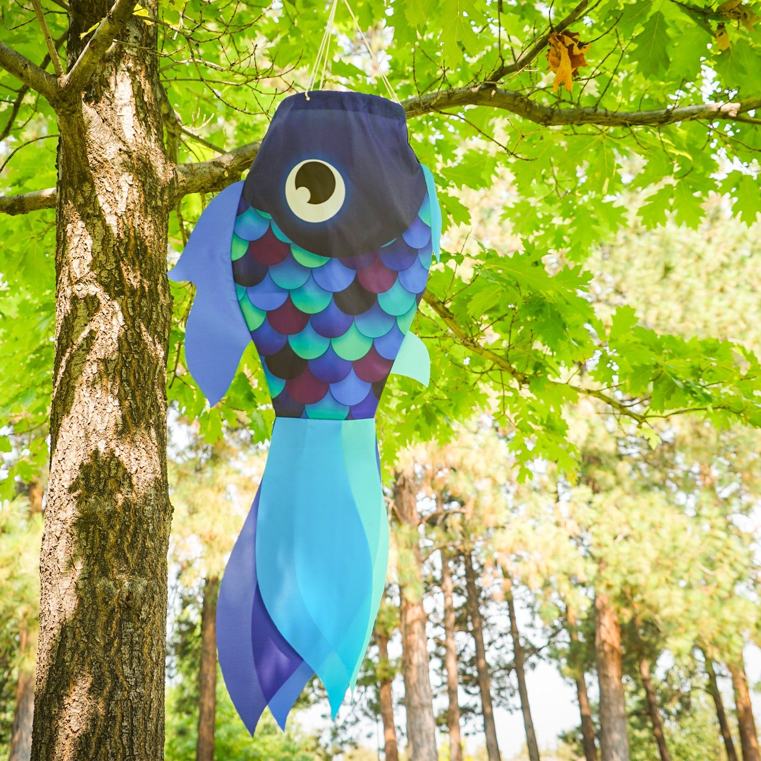 30-inch Cool Damsel Fish windsock in vibrant blue colors hanging outdoors, fluttering in the wind with colorful fins moving freely.