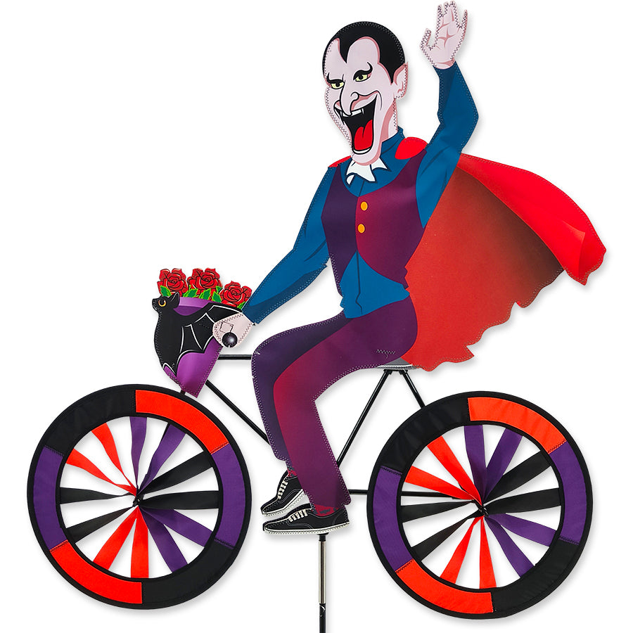 30 in. Bike Spinner featuring vibrant Dracula design, gracefully spinning in a garden setting on a sunny day.