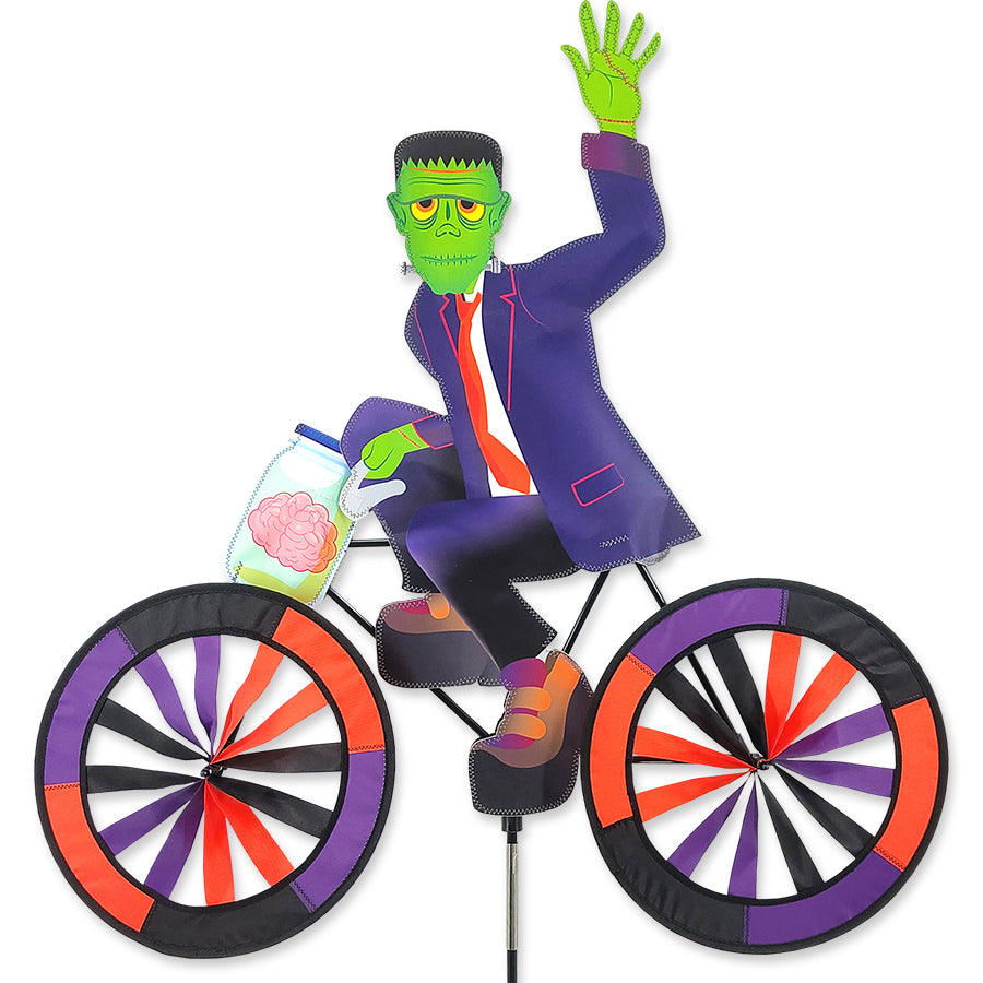 30 in. Bike Spinner featuring a colorful Frankenstein design, spinning gracefully in outdoor sunlight on a bicycle.