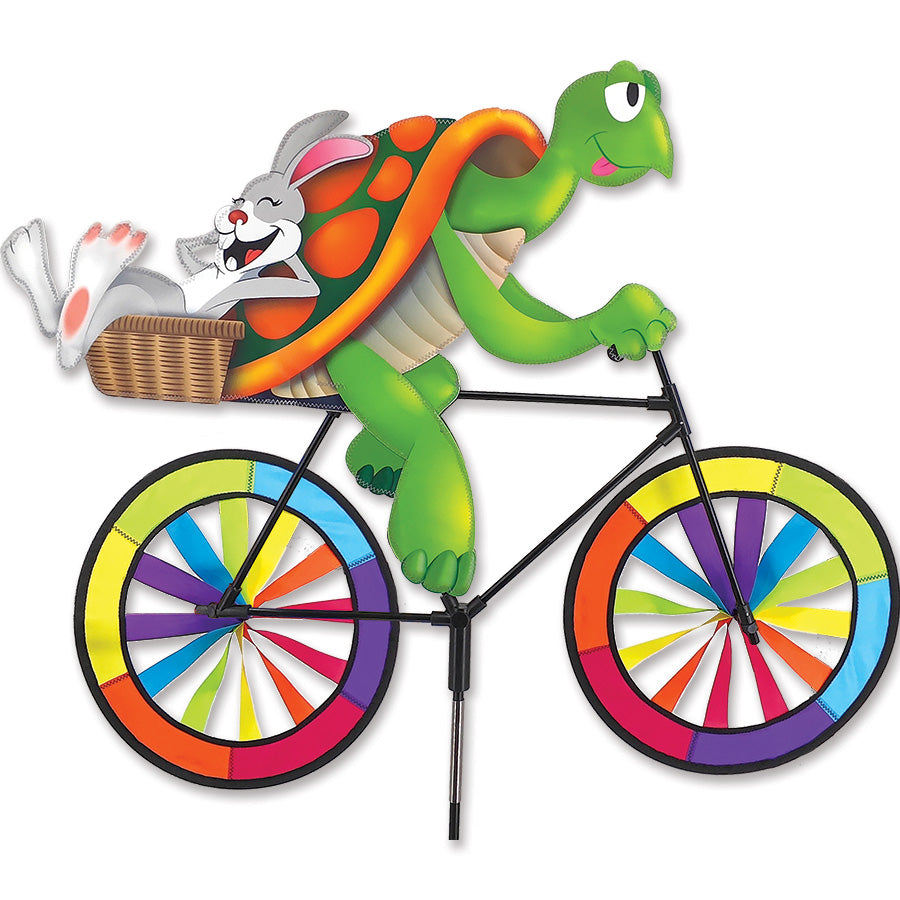 30 in. Bike Spinner featuring a joyful rabbit on a turtle's bicycle with vibrant rainbow wheels spinning in the outdoor breeze.