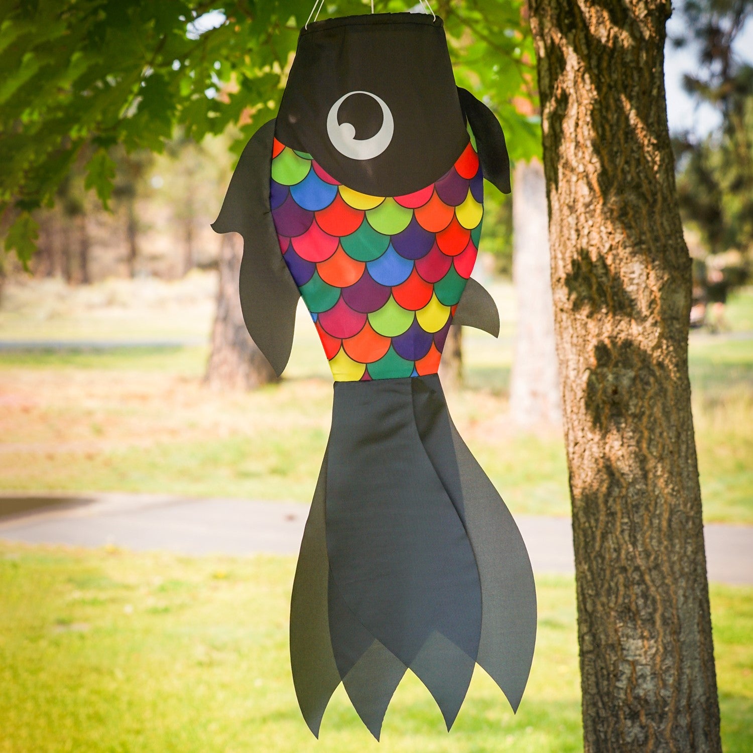 30-inch Black & Rainbow Damsel Fish Windsock swaying in a gentle breeze, featuring flowing fins and colorful design suitable for outdoor decor.