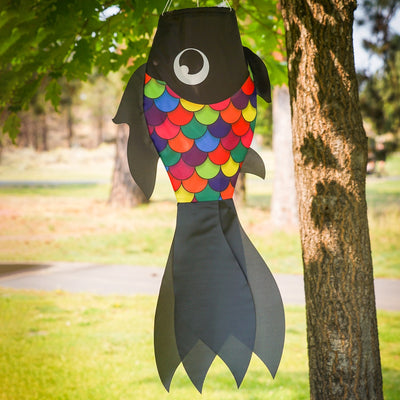 30-inch Black & Rainbow Damsel Fish Windsock swaying in a gentle breeze, featuring flowing fins and colorful design suitable for outdoor decor.