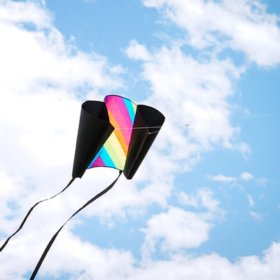 30-inch Neon Fiesta Stripe Sled Kite in vibrant colors flying high with black tails, suitable for beginners and easy to pack.