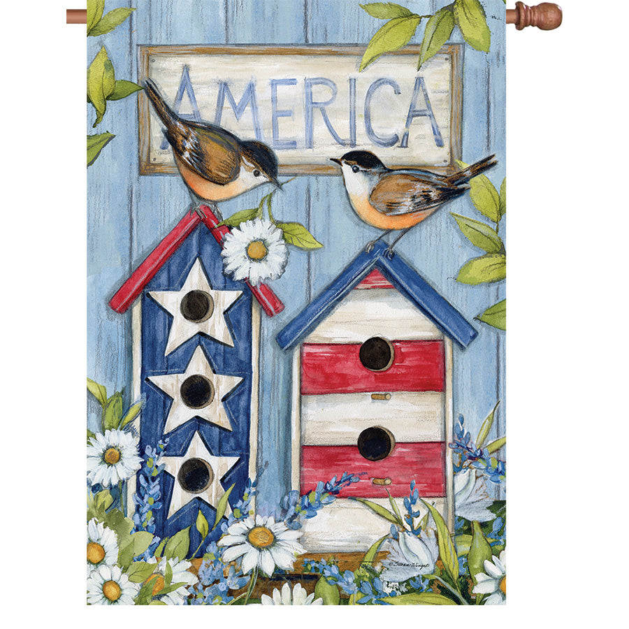 36 in. Elite Oversized House Flag with colorful birdhouse design fluttering on a flag pole in a garden setting.