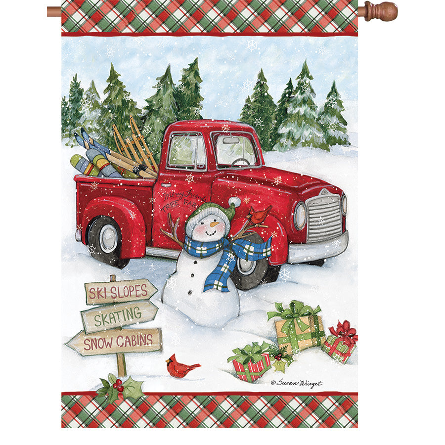 36 in. Elite Oversized House Flag with a red truck snowman design, displayed on a flag pole in a wintry outdoor setting.