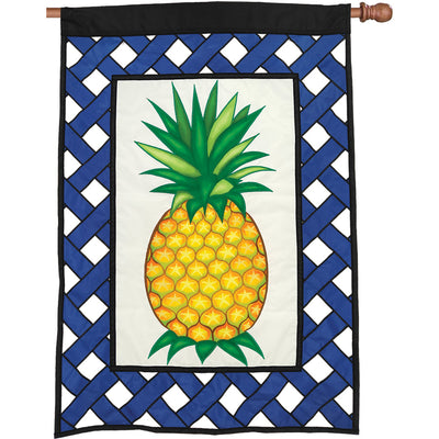 36 in. Elite Oversized Lattice Flag featuring a colorful pineapple design, gracefully displayed outside on a flag pole in a sunny garden setting.