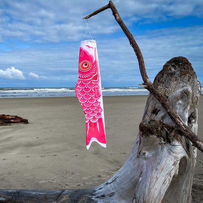 36-inch Pink Koi windsock displaying bright colors in a garden, fluttering gently in the breeze, designed for outdoor decoration and celebrations.