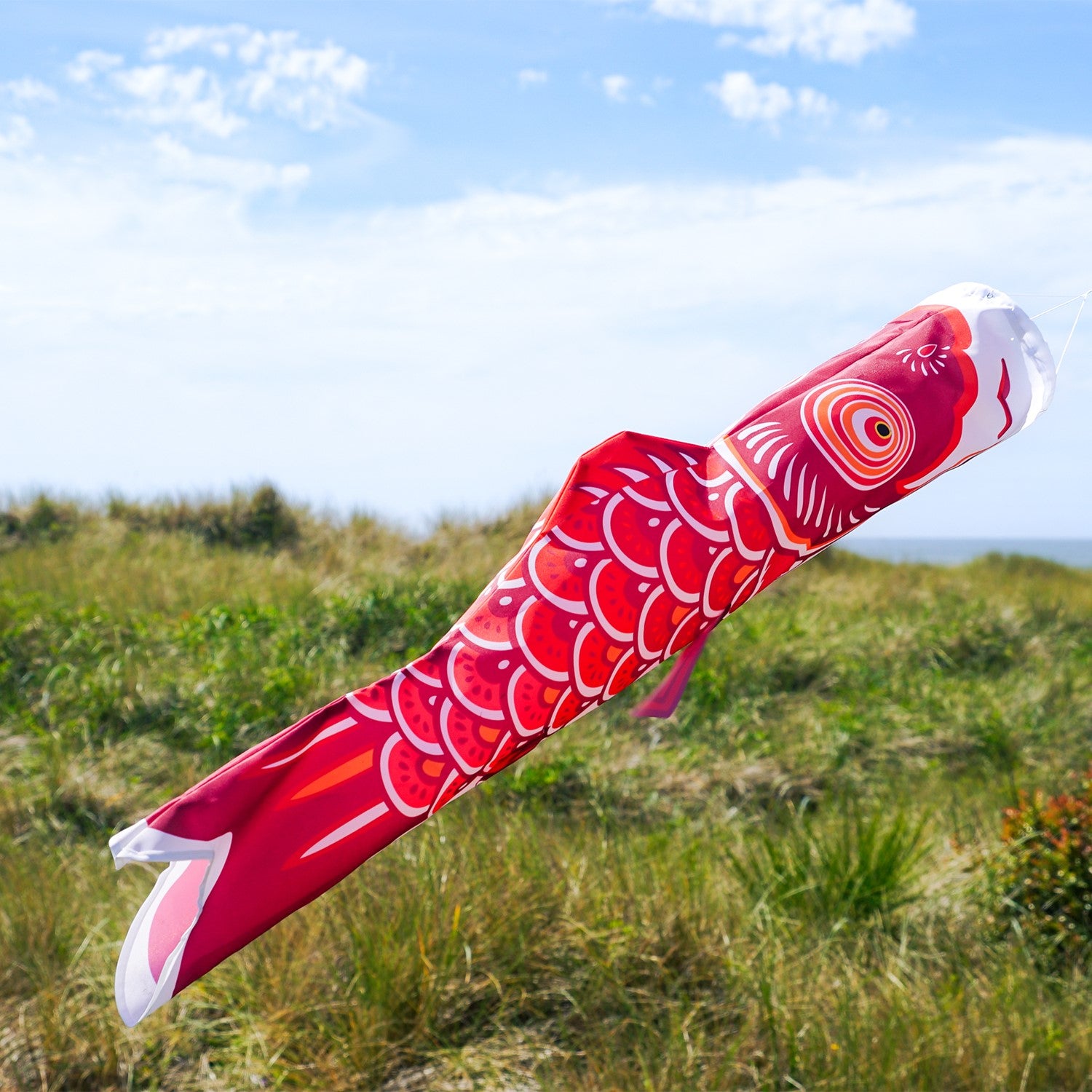 36-inch Red Koi Windsock featuring vibrant colors and detailed patterns, gently swaying in an outdoor garden setting.