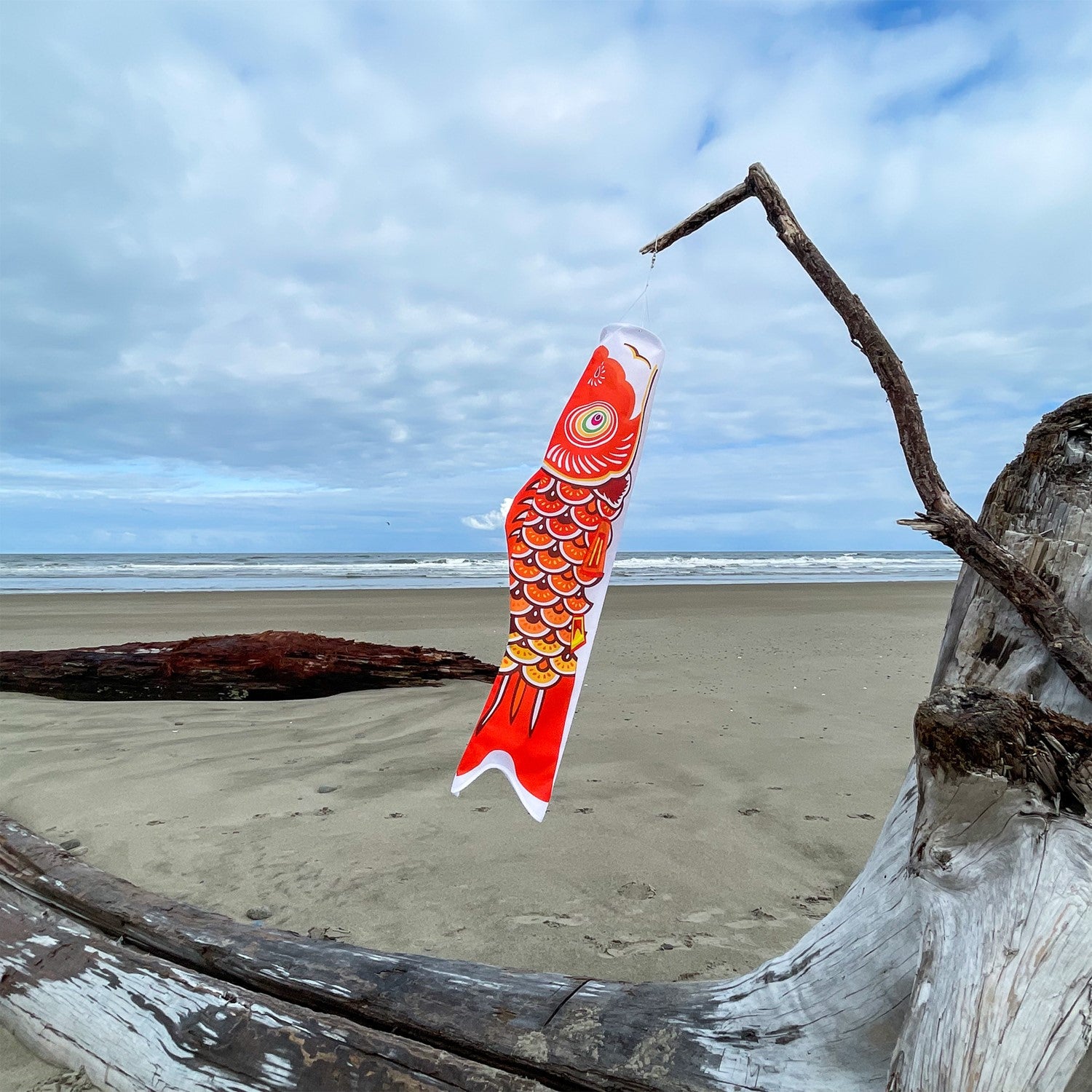 36-inch vibrant Orange Koi windsock, crafted from weather-resistant fabric, elegantly displayed in a garden setting to add color and charm.