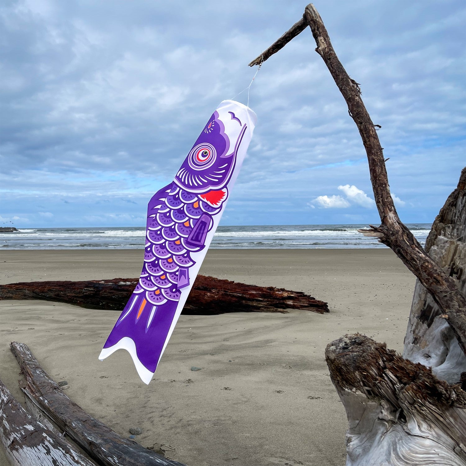36" Purple Koi windsock hanging outside, showcasing vibrant colors and intricate fish details, fluttering in the wind.