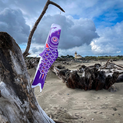 36" Purple Koi windsock hanging outside, showcasing vibrant colors and intricate fish details, fluttering in the wind.