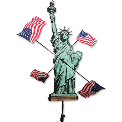 38 in. WhirliGig Spinner - Lady Liberty featuring a vibrant USA flag design, spinning gracefully in a garden setting under blue skies.