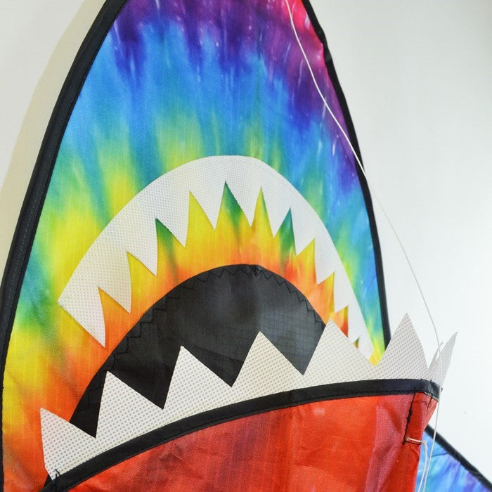 5-foot 3D Tie Dye Shark Kite flying high against a blue sky, showcasing its vibrant colors and fun design as it swims through the air.